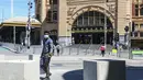Seorang pria dengan masker berjalan melewati Stasiun Flinders Street di Melbourne, Australia, Rabu (28/10/2020). Melbourne, kota terbesar kedua Australia, akhirnya dibuka kembali usai pemberlakuan lockdown yang ketat selama lebih dari tiga bulan akibat Covid-19.  (AP Photo/Asanka Brendon Ratnayake)