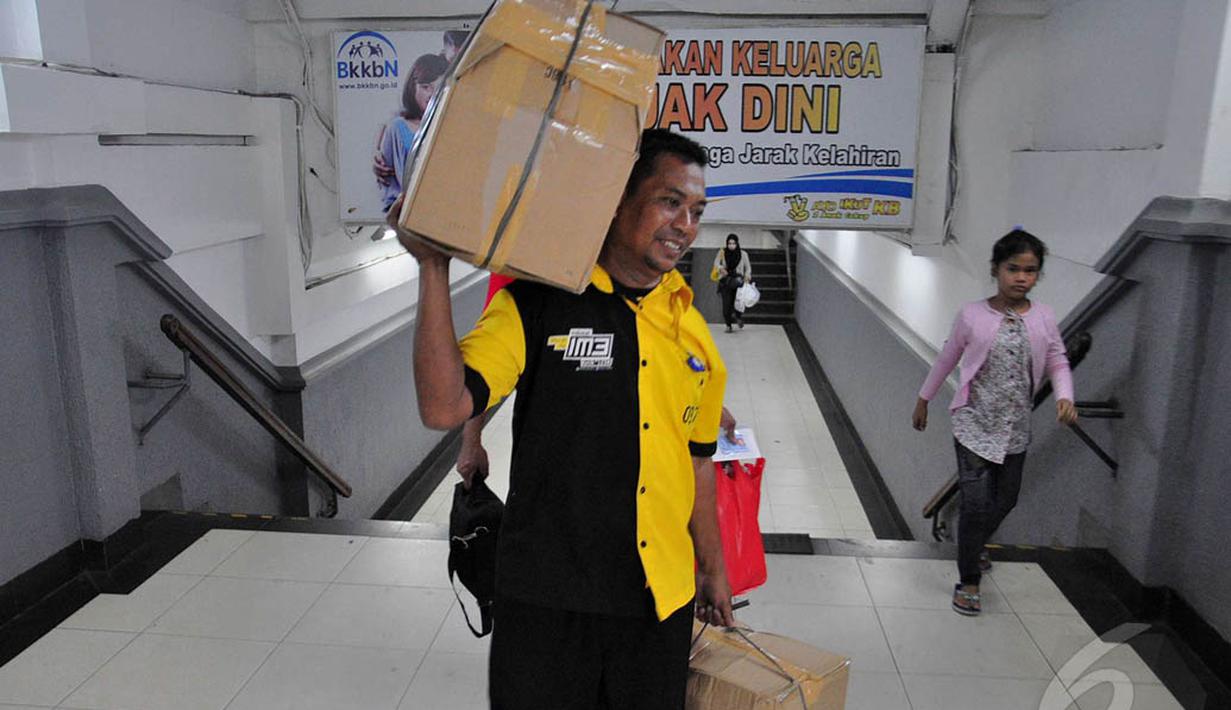 Seorang kuli panggul di Stasiun Pasar Senen terlihat mengangkut barang bawaan pemudik, Jakarta, Jumat (1/8/14). (Liputan6.com/Faizal Fanani)