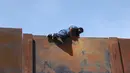 Seorang pemuda memanjat tembok besi perbatasan antara Meksiko dan Amerika Serikat di negara bagian Chihuahua, Meksiko (6/4). Mereka menyeberang secara ilegal ke Sunland Park dari Ciudad Juarez. (AFP/Herika Matinez)