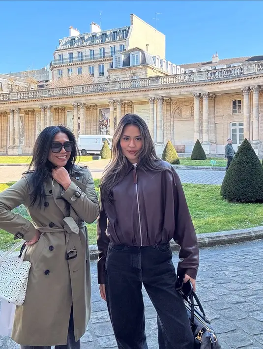 Anggun C Sasmi bergaya Parisian kenakan trench coat dengan baggy jeans dan hand bag putih [@anggun_cipta)