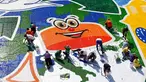 Sejumlah relawan membuat mosaik raksasa dari 100 ton limbah tutup botol dalam acara "A Bottle Cap for Handicap" di kota Novi Sad, Serbia, Sabtu (30/9). Pembuatan mosaik berukuran 621 meter persegi tersebut melibatkan 300 relawan. (AP/Darko Vojinovic)