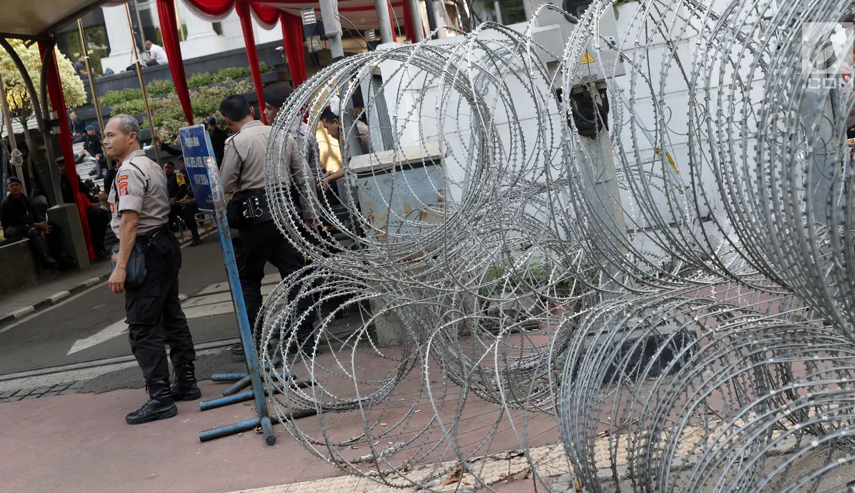 Personel Kepolisian berjaga di depan Gedung Mahkamah Konstitusi (MK), Jakarta, Selasa (25/6/2019). Jelang sidang pembacaan putusan akan digelar pada Kamis (27/6), penjagaan di sekitar Gedung Mahkamah Konstitusi diperketat. (Liputan6.com/Helmi Fithriansyah)
