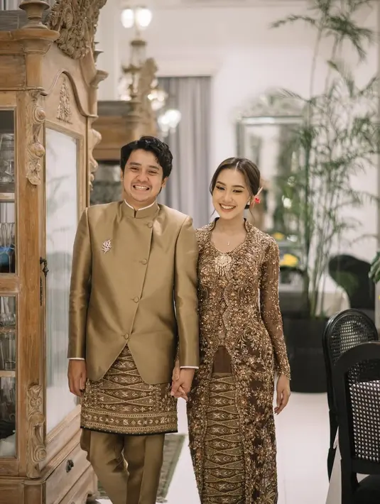 Busana rancangan desainer @guginugraha ini menonjolkan siluet tubuh Raissa secara anggun, dengan detail payet dan bordiran yang rumit, menciptakan kesan megah namun tetap lembut. Nuansa bronze yang hangat memberikan sentuhan klasik yang tetap relevan di momen sakral seperti lamaran.  [@raissarmdhn].