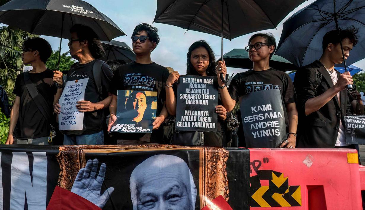 Para aktivis memegang payung hitam dan poster selama Aksi Kamisan di depan Istana Kepresidenan, Jakarta, Kamis 30 April 2026. Hari ini, Kamis 30 April 2026, Aksi Kamisan ke-906 dilaksanakan seperti biasa. (BAY ISMOYO/AFP)