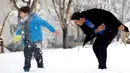 Warga Iran bermain salju di Teheran, Selasa (24/1). Hampir setengah abad salju tak turun di Iran dan sejak 2011 hingga kini salju senantiasa turun di musim dingin. (AFP PHOTO / ATTA KENARE)   