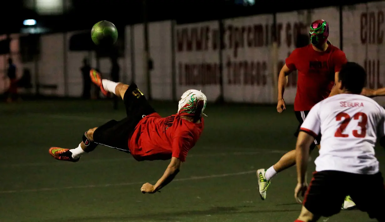 Aksi Pegulat menendang bola saat bermain futsal di Monterrey, Meksiko (29/2). Sejumlah pegulat profesional Meksiko mencoba hal baru bermain futsal untuk melatih kebugaran pegulat. (REUTERS/Daniel Becerril)