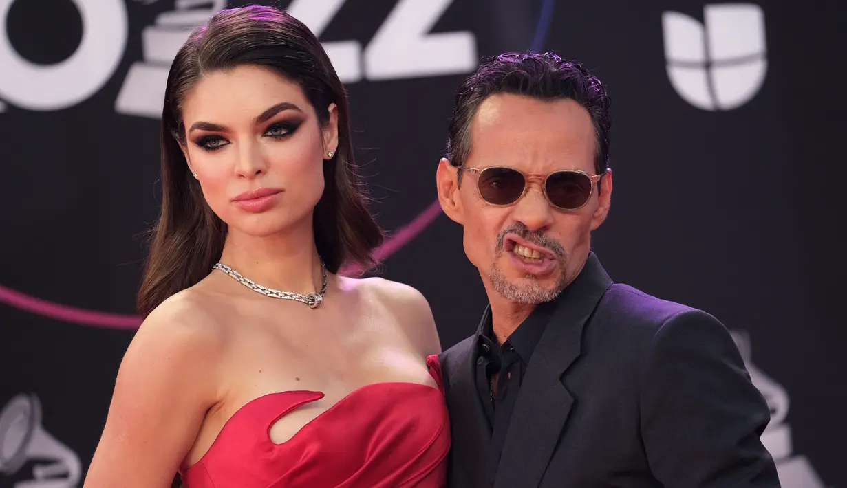 Marc Anthony bersama tunangannya model Paraguay Nadia Ferreira berpose saat tiba menghadiri penghargaan Grammy Latin ke-23 di Michelob Ultra Arena Mandalay Bay di Las Vegas, Nevada, pada 17 November 2022. Ferreira memukau penonton dalam gaun satin merah strapless yang terinspirasi Jessica Rabbit yang memeluk pinggang mungil dan pinggulnya yang indah. (AFP/Chris Delmas)