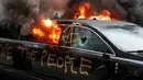 Sebuah mobil limusin dibakar oleh para pengunjuk rasa saat terpakir selama protes pelantikan Presiden Donald Trump di Washington, DC, AS, (20/1). selain membakar para pengunjuk rasa mencoret-coret mobil mewah tersebut. (AP Photo/John Minchillo)