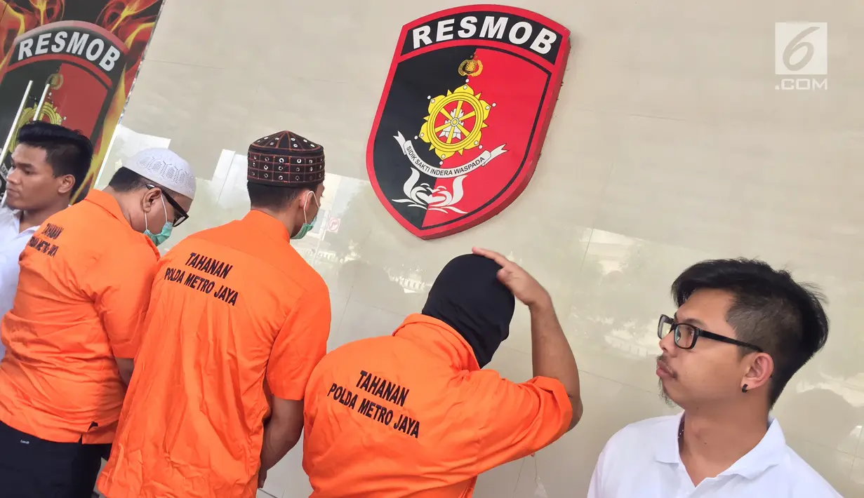 Sejumlah tersangka kasus pemalsuan, pencurian data elektronik, dan pencucian uang ditampilkan di Polda Metro Jaya, Jakarta, Senin (18/12). Polda Metro Jaya berhasil menangkap sembilan orang WNA dan tiga orang WNI. (Liputan6.com/Immanuel Antonius)
