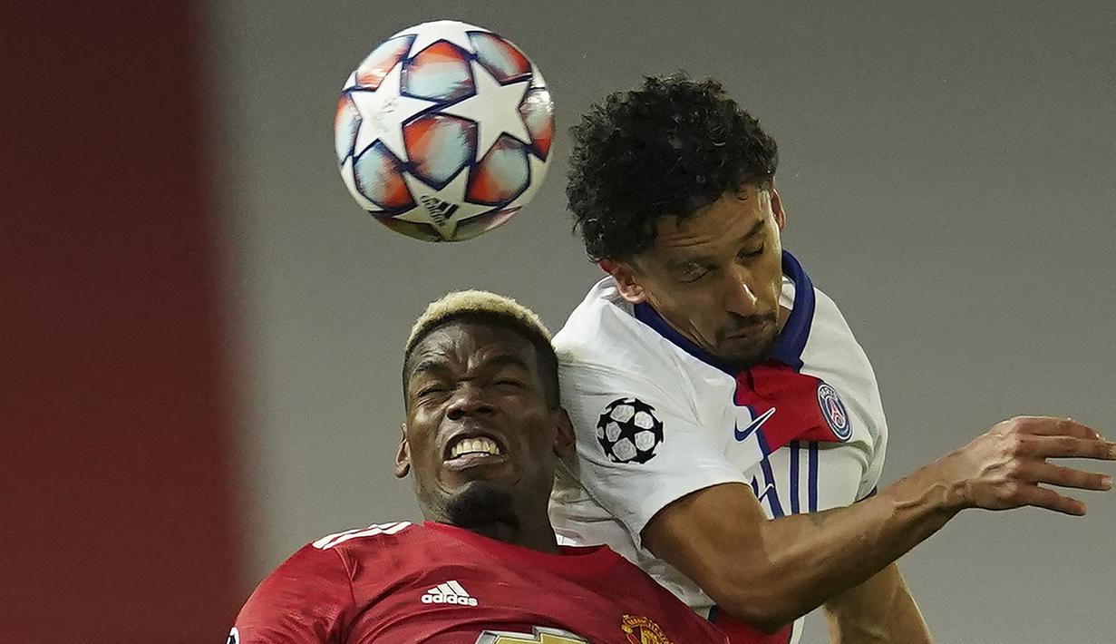 Gelandang Manchester United, Paul Pogba (kiri), berduel udara dengan bek Paris Saint-Germain, Marquinhos, dalam laga lanjutan Liga Champions 2020/21 Grup H di Old Tarfford Stadium, Manchester, Rabu (2/12/2020) waktu setempat. Manchester United kalah 1-3 dari PSG. (AP/Dave Thompson)