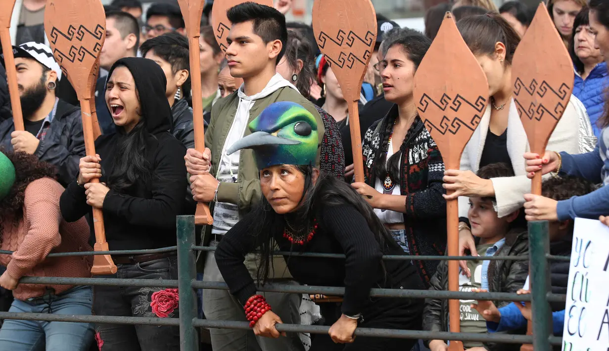 Demonstran memegang dayung kano selama protes menyerukan Presiden Brasil Jair Bolsonaro untuk melindungi hutan Amazon di depan Kedutaan Brasil, Lima, Peru, Jumat (23/8/2019). (AP Photo/Martin Mejia)