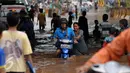 Seorang wanita membantu mendorong motor yang mogok saat berusaha menerobos banjir di Jalan Raya Kalimalang, Caman, Bekasi, Senin (20/2). Akibat banjir tersebut, arus lalu lintas di Kalimalang macet parah. (Liputan6.com/Gempur M Surya)