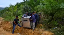 Petugas Balai Konservasi Sumber Daya Alam (BKSDA) Aceh membawa kandang evakuasi yang berisi seekor harimau sumatra liar yang berhasil ditangkap di Desa Singgersing, Kota Subulussalam, Aceh, Minggu (8/3/2020). Penangkapan harimau dilakukan dengan menggunakan kandang jebak. (CHAIDEER MAHYUDDIN/AFP)