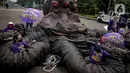 Sejumlah massa aksi berada di antara replika gurita raksasa oligarki saat aksi di Patung Kuda, Jakarta, Selasa (8/3/2022). Aksi tersebut untuk memperingati Hari Perempuan Internasional serta menuntut pengesahan RUU TPKS yang partisipatif dalam pembahasan dan pro korban. (Liputan6.com/Faizal Fanani)