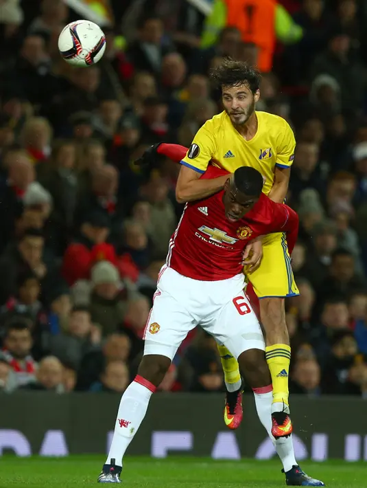 Gelandang Manchester United, Paul Pogba berebut bola dengan gelandang Rostov, Aleksandr Erokhin pada babak 16 Liga Europa di Stadion Old Trafford, Inggris (16/3). MU menang atas Rostov dengan skor 1-0 agregat (2-1). (AP Photo/Dave Thompson)