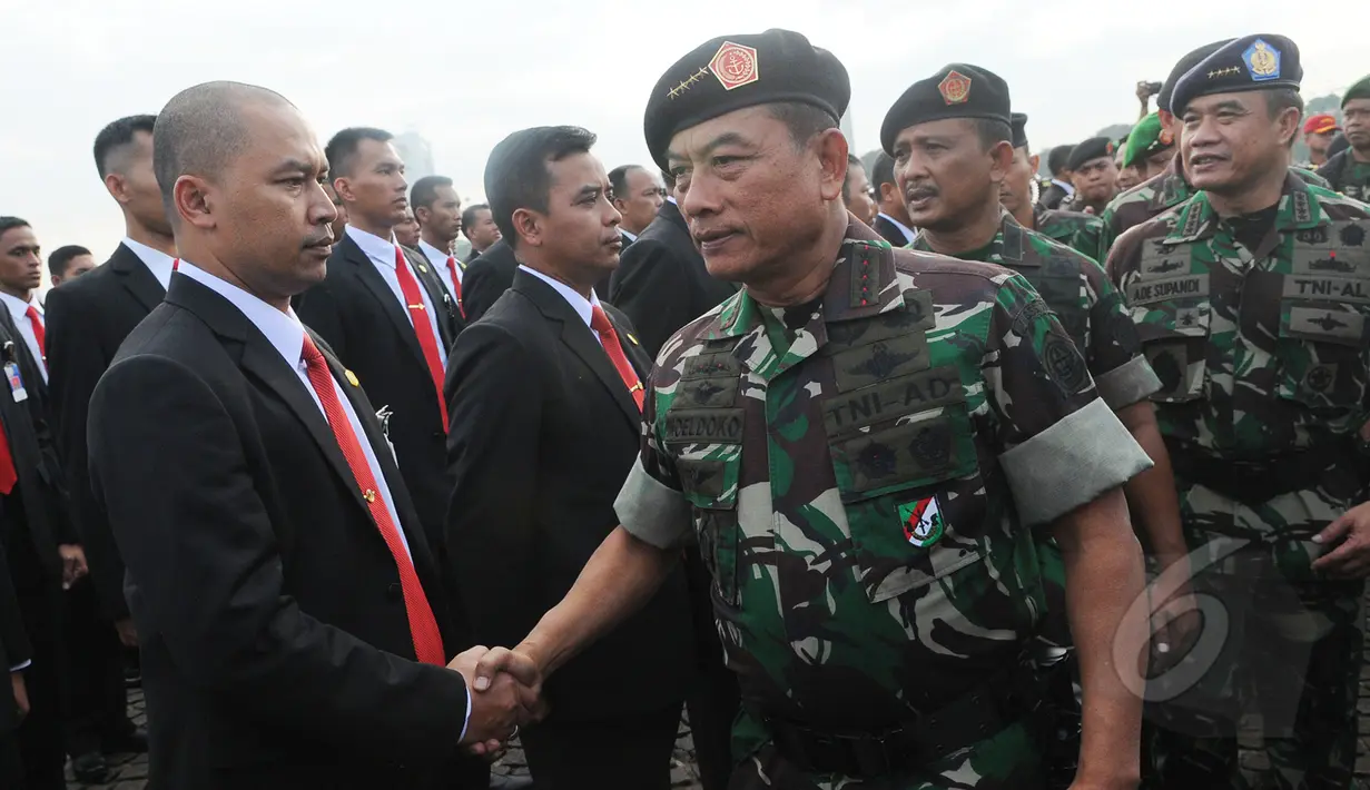 Panglima TNI Jenderal TNI Moeldoko menyalami anggota Paspampres saat apel gelar pasukan di kawasan Monas, Jakarta, Rabu (15/4/2015). KAA ke-60 akan berlangsung pada 18-24 April 2015 di Jakarta dan Bandung. (Liputan6.com/Herman Zakharia)