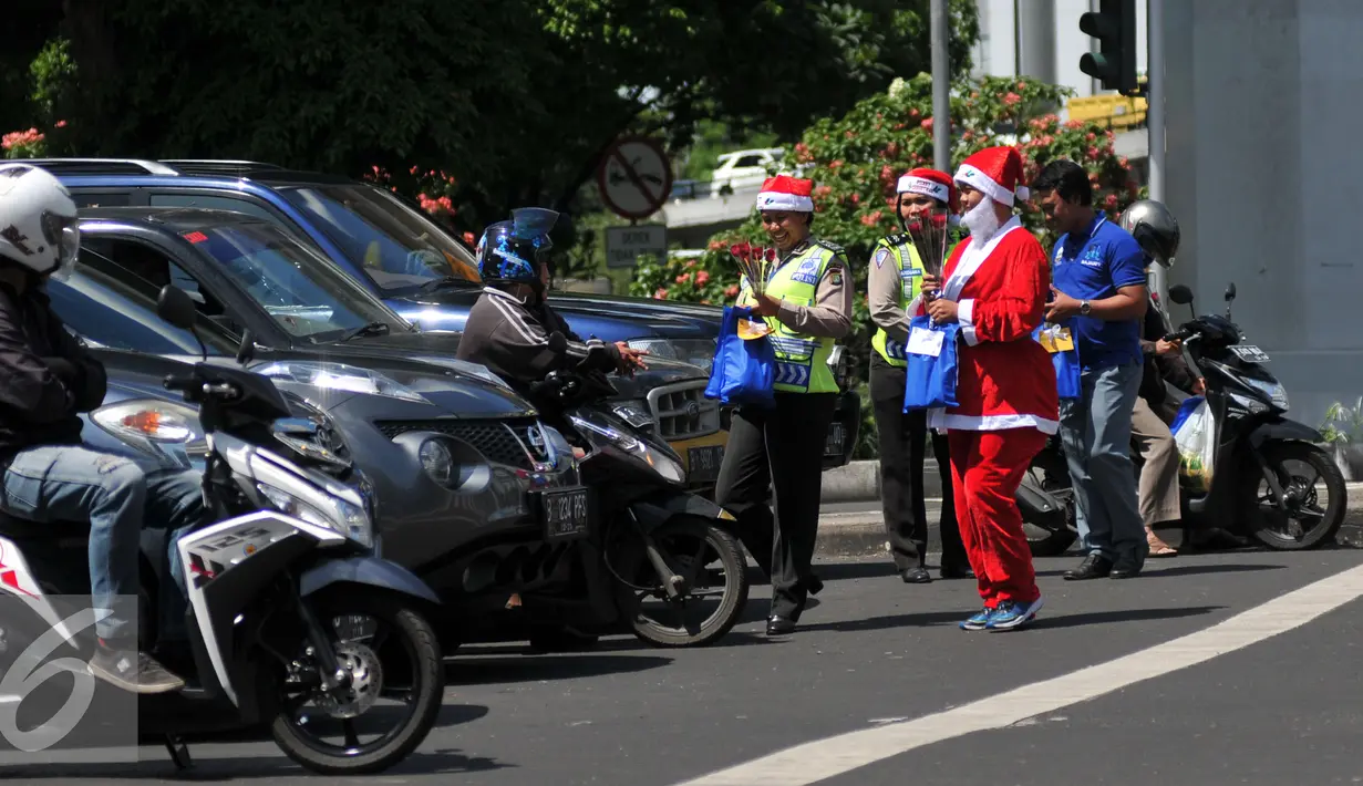 Petugas Kepolisian bersama sinterklas saat membagikan bunga dan masker di jalan kawasan Tomang, Jakarta, Rabu (23/12). Menyambut Hari Natal 2015, anggota Kepolisian Polres Jakarta Barat kenakan topi Sinterklas. (Liputan6.com/Yoppy Renato)