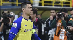 Penyerang Al Nassr, Cristiano Ronaldo memasuki lapangan untuk memainkan pertandingan melawan Al Ettifaq pada Liga Pro Saudi di Stadion Mrsool Park, di Riyadh, Arab Saudi, Minggu (22/1/2023). Ronaldo yang menjalani laga debut dengan bertindak sebagai kapten tim. (AP Photo)