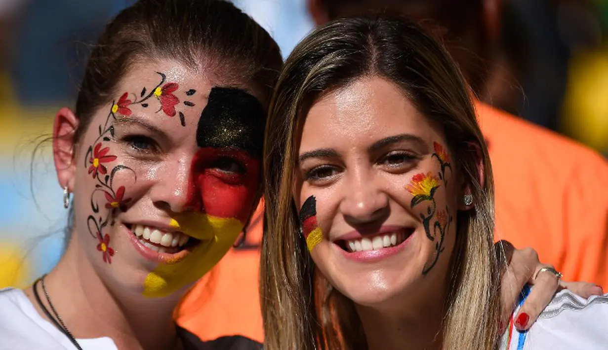 Para suporter menghiasi wajahnya dengan coretan warna bendera Jerman saat laga final piala dunia, Brasil, Senin (14/7/14). (AFP/ODD ANDERSEN)