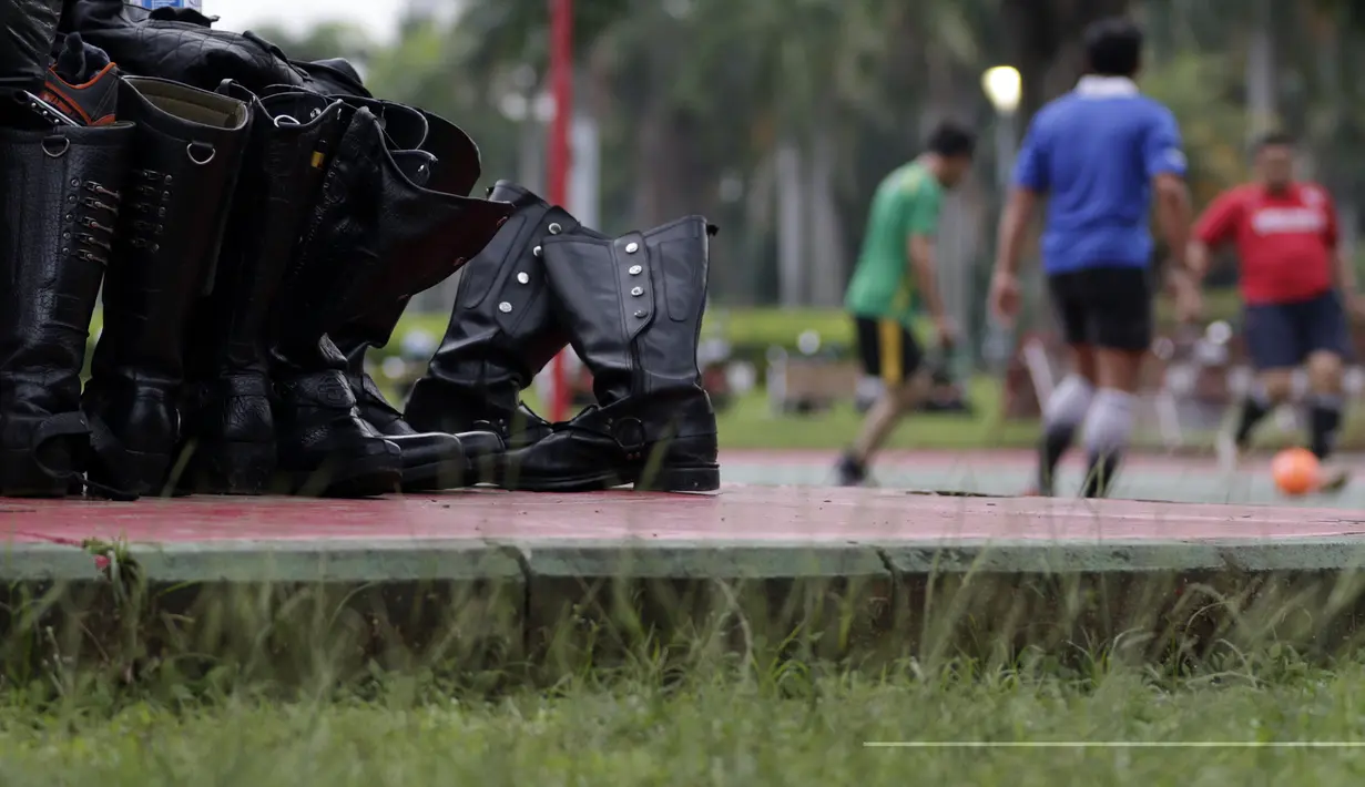 Sepatu Petugas Dishub ditaruh saat olahraga sepak bola di Kawasan Monumen Nasional, Jakarta, Rabu (13/2). Monas merupakan salah satu lokasi yang kerap dijadikan ruang olahraga bagi warga ibukota. (Bola.com/M. Iqbal Ichsan)