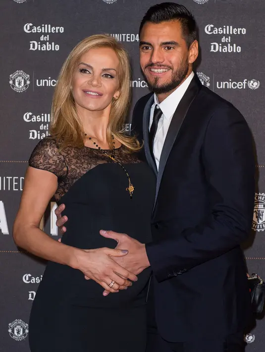 Kiper Manchester United, Sergio Romero dan istrinya, Eliana Guercio berpose di karpet merah makan malam acara amal UNICEF di Old Trafford, Rabu (15/11). Event ini sekaligus ajang pamer istri dan kekasih (WAGs) pasukan Red Devils. (Paul ELLIS/AFP)