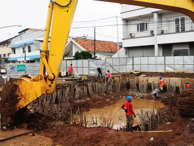 Pekerja menyelesaikan proyek tahap awal galian sodetan Kali Ciliwung di kawasan Otista, Jakarta, Kamis (10/7/14). (Liputan6.com/Faizal Fanani)