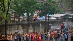 Seorang penganut Hindu tergantung dengan kaitan yang ditusuk di punggungnya saat festival Charak Puja di Dhaka, Bangladesh (14/4). Mereka juga percaya festival ini dapat menghilangkan kesedihan dan penderitaan tahun sebelumnya. (AP Photo / A.M. Ahad)