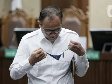 Terdakwa kasus dugaan penerimaan gratifikasi dan tindak pidana pencucuian uang (TPPU) Rafael Alun Trisambodo bersiap mengenakan masker usia menjalani sidang pembacaan putusan di Pengadilan Tipikor, Jakarta, Kamis (4/1/2024). (Liputan6.com/Faizal Fanani)