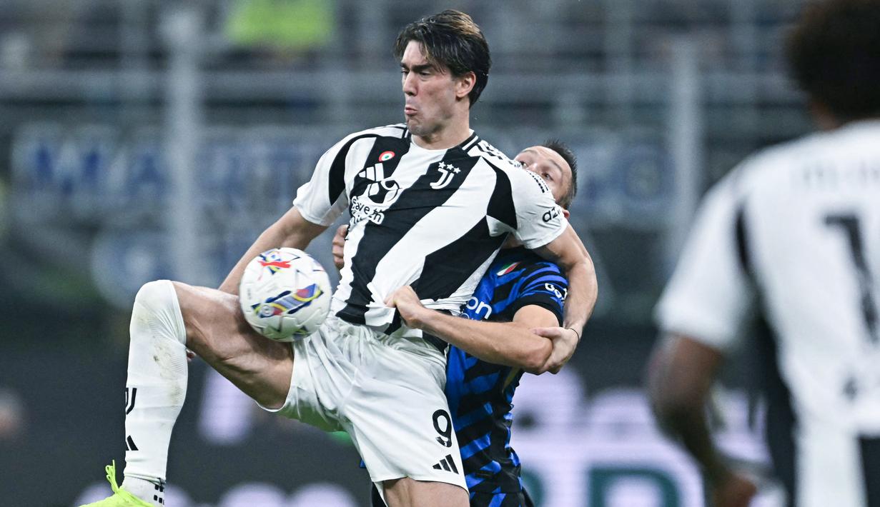 Pemain Inter Milan, Stefan de Vrij, berebut bola dengan pemain Juventus, Dusan Vlahovic, pada laga Liga Italia di Stadion Giuseppe Meazza, Minggu (27/10/2024). (AFP/Gabriel Bouys)
