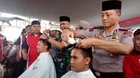 Nampak Kapolres Budi terlihat lihat memotong salah satu rambut salah satu anggota polres Garut, dalam penggalangan dana korban tsunami Selat Sunda siang tadi (Liputan6.com/Jayadi Supriadin)