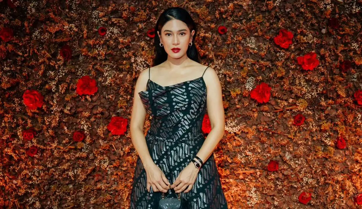 <p>Dian Sastro mengenakan gaun maxi bertali dengan motif batik parang dan bernuansa silver hitam. [@hagaipakan]</p>