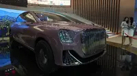 Promotor saling berbisik dekat kendaraan konsep dari merek mobil mewah China Hongqi yang ditampilkan pada pameran Auto Shanghai 2023. (AP Photo/Ng Han Guan)