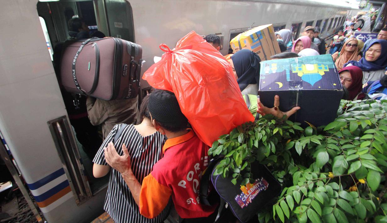 Peserta mudik gratis bareng PDIP menaiki kereta api di Stasiun Pasar Senen, Jakarta, Selasa (12/6). PDIP memberangkatkan 725 pemudik dengan kereta api pada hari ini. (Liputan6.com/Angga Yuniar)