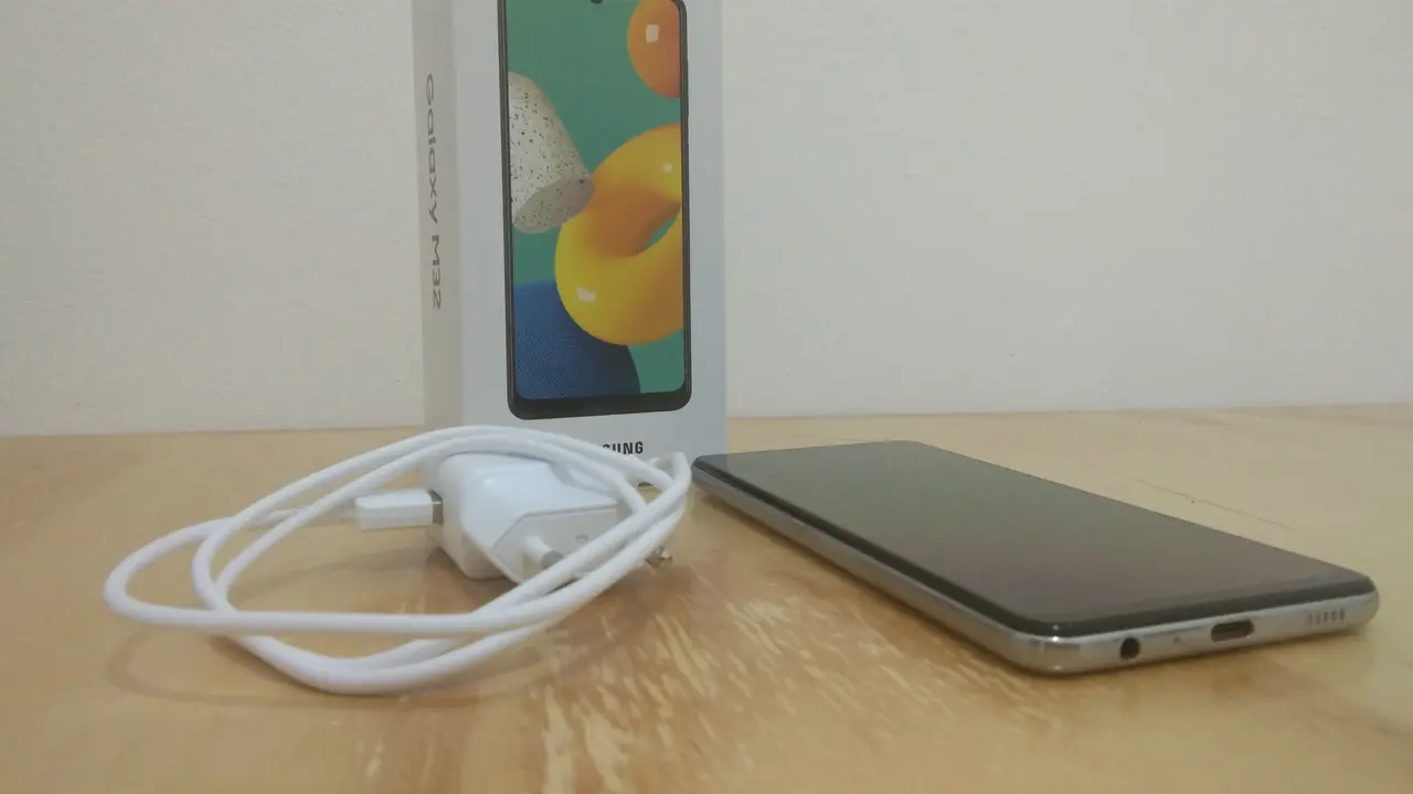 Ponsel Samsung Galaxy M32 dan adapter serta kabel charger (Liputan6.com/Giovani Dio Prasasti)