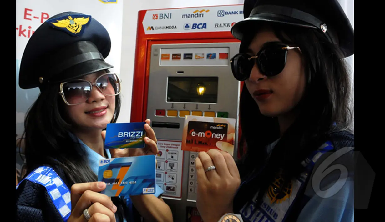Dua orang Pramuniaga menunjukan beberapa kartu E-money yang dapat digunakan untuk pembayaran parkir di Terminal Parkir Elektronik (TPE), Jakarta, Kamis (29-01-2015). Sebanyak enam bank terlibat dalam sistem pembayaran ini. (Liputan6.com/Andrian M Tunay)