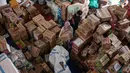 Para relawan mengemasi perlengkapan untuk dikirimkan ke daerah-daerah terdampak banjir di Badan Penanggulangan Bencana Daerah (BPBD) Sidoarjo, Provinsi Jawa Timur, pada Jumat 5 Desember 2025. (JUNI KRISWANTO/AFP)