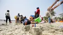 Seorang anak bermain pasir di Pantai Lagoon, Ancol, Jakarta Utara, Jumat (17/8). Libur panjang akhir pekan ini yang bertepatan dengan HUT ke-73 RI, sejumlah warga memadati tempat rekreasi di kawasan Ibu Kota . (Liputan6.com/Faizal Fanani)
