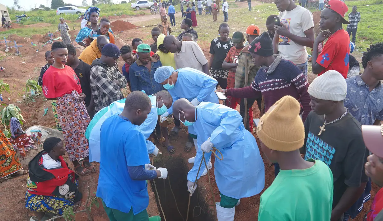 Orang-orang yang mengenakan pakaian pelindung  menurunkan peti jenazah seorang anak berusia enam tahun yang meninggal akibat Ebola, ke dalam liang lahat di Bunia, Provinsi Ituri, Kongo timur, Selasa, 18 Agustus 2026. (Foto AP/Dieudonne Dirole)