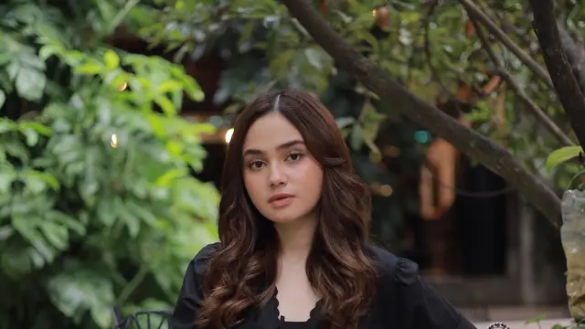 Syifa Hadju duduk di sebuah taman dengan menampilkan Tabby Shoulder Bag 20 Coach (Foto Dok: KANMO GROUP)