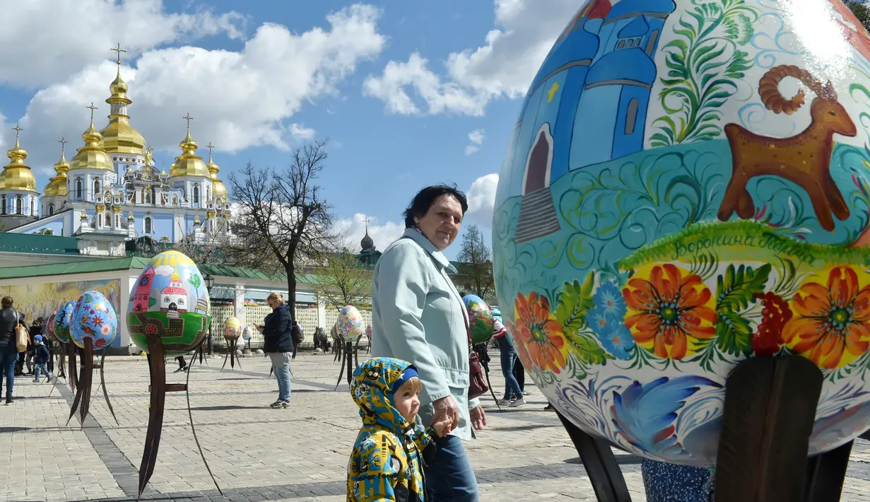 Pengunjung melihat telur Paskah yang dipajang di depan Katedral Mikhaylivsky di pusat Kiev sebelum perayaan Paskah, Ukraina, Rabu (12/4). Pameran telur Paskah ini biasa digelar menjelang perayaan Paskah. (AFP PHOTO / Sergei SUPINSKY)
