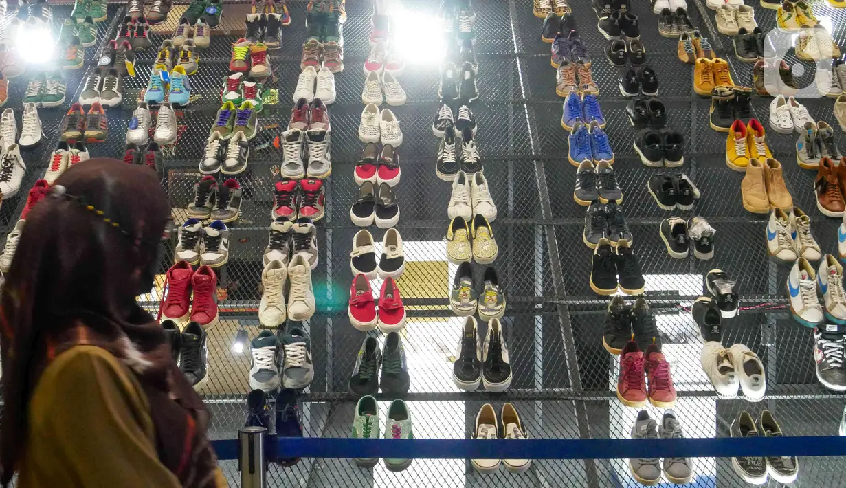 Pengunjung mengamati produk yang ditawarkan pada acara Urban Sneaker Society 2021 di JCC, Senayan, Jakarta, Minggu (5/12/2021). Urban Sneaker Society kali ini menghadirkan berbagai brand lokal pilihan mulai dari Streetwear Brand, Sneaker Market, Thrift. (Liputan6.com/Herman Zakharia)