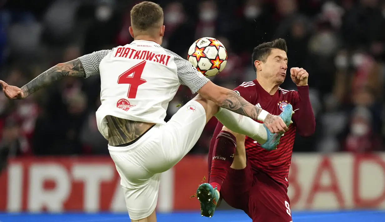 Pemain Salzburg Kamil Piatkowski (kiri) berebut bola dengan pemain Bayern Munchen Robert Lewandowski pada pertandingan leg kedua babak 16 besar Liga Champions di Munich, Jerman, 8 Maret 2022. Bayern Munchen menang 7-1. (AP Photo/Matthias Schrader)