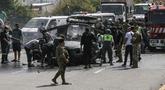 Petugas tanggap darurat bekerja di sekitar kendaraan yang menjadi sasaran serangan pesawat tak berawak Israel di jalan raya dekat kota Jiyeh, Selatan Beirut, pada Rabu 13 Mei 2026. (MAHMOUD ZAYYAT/AFP)