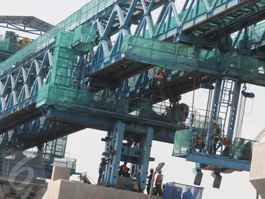 Sejumlah pekerja menyelesaikan kontruksi crane Mass Rapid Transit (MRT) di Kawasan Lebak Bulus, Jakarta, Minggu (12/6). Gubernur Basuki Tjahja Purnama (Ahok) mengatakan, MRT bukan untuk Asian Games karena baru siap pada 2019. (Liputan6.com/Helmi Afandi)