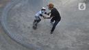 Instruktur melatih seorang anak menggunakan skateboard dengan memakai masker dan face shield di Crooz Shophouse di kawasan Duren Tiga, Jakarta Selatan, Minggu (2/8/2020). Mereka kembali melakukan latihan seminggu dua kali dengan menerapkan protokol kesehatan. (merdeka.com/Arie Basuki)