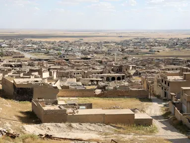 Bangunan-bangunan yang rusak akibat serangan militan Negara Islam (ISIS) tahun 2014 dan pertempuran setelahnya, berdiri di kota Sinjar di provinsi Nineveh, Irak utara, pada 6 Mei 2024. (Safin HAMID / AFP)
