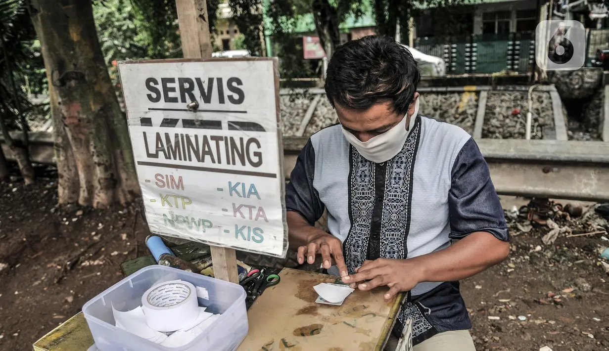 Feri (28) saat menyelesaikan jasa servis kartu tanda penduduk (KTP) di Jakarta, Kamis (21/1/2021). Harga servis dibanderol Rp 10.000 - Rp 20.000 per kartu, tergantung tingkat kesulitan perbaikan. (merdeka.com/Iqbal S. Nugroho)