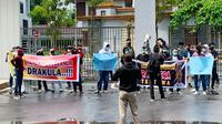 Demonstrasi di Kejati Riau yang membawa spanduk berisi karikatur Gubernur Riau Syamsuar dan tulisan Tangkap Gubernur Drakula. (Liputan6.com/M Syukur)