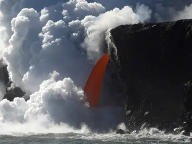 Aliran lava memancar deras dari gunung berapi Kilauea di Hawaii ke Samudra Pasifik, Rabu (1/2). Pertunjukkan alam tersebut menciptakan air terjun lava. (Shane Turpin / Lava Ocean Tours via AP)