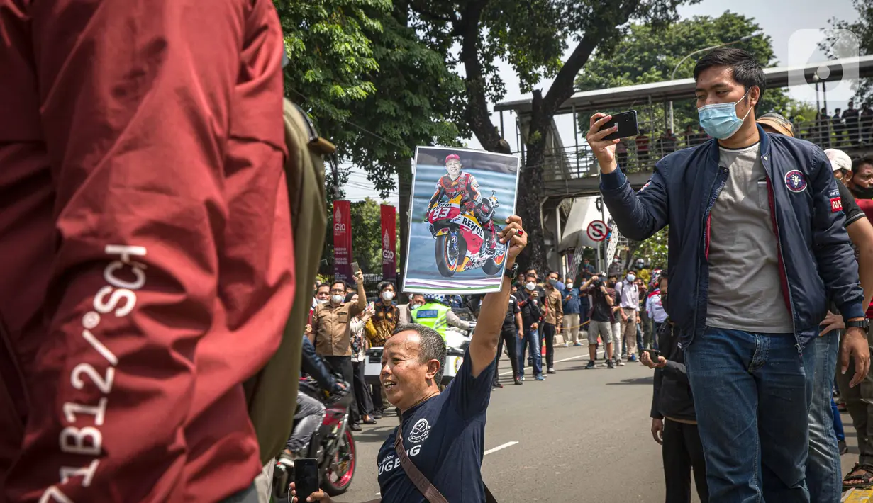 Antusias warga menyaksikan parade pembalap MotoGP di kawasan Jakarta, Rabu (16/3/2022).  Sebanyak 20 pembalap MotoGP menjajal ruas Jalan Sudirman-Thamrin, Jakarta Pusat hari ini. (Liputan6.com/Faizal Fanani)